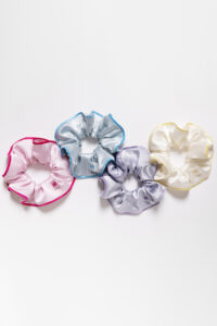 Collection of Macaron Large Silk Scrunchies in pink, blue, lavender, and cream arranged on a white background.