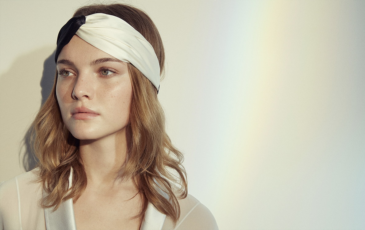 Chic woman showcasing MANITO's contrast silk headband, blending elegance and comfort in a minimalist setting