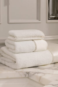 Aqua 3 Pieces Bath Towel Set stacked on marble counter, made from Sea Island cotton and mulberry silk for a soft, luxurious feel.