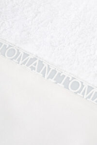 Close-up of MANITO hollow lace logo on Aqua Bath Towel, highlighting exquisite yarn weaving and fine craftsmanship.