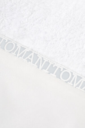 Close-up of MANITO hollow lace logo on Aqua Bath Towel, highlighting exquisite yarn weaving and fine craftsmanship.