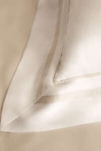 Detail shot of the edge finishing on MANITO Authentic Silk Duvet Cover in champagne shade color.