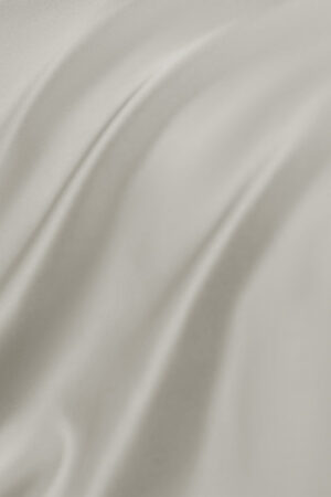 Soft folds and sheen of the taupe-colored MANITO Authentic Silk Fitted Sheet fabric.