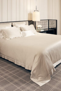 MANITO Authentic Silk Flat Sheet displayed on a luxury bed setting with matching silk pillowcases.