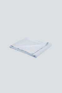 Neatly folded MANITO Authentic Silk Flat Sheet in light blue, highlighting fine stitching.