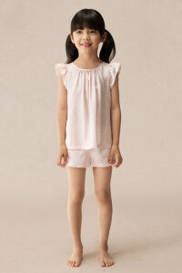 Full front view of BONPOINT×MANITO Ailette Kid's Pajama Set modeled by a girl, showing soft pink silk top and shorts.