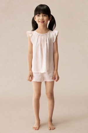 Full front view of BONPOINT×MANITO Ailette Kid's Pajama Set modeled by a girl, showing soft pink silk top and shorts.