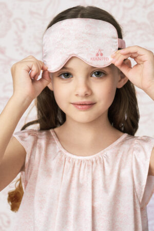 Child adjusting silk eye mask from BONPOINT×MANITO Ailette Kid's Pajama Set Gift Box.