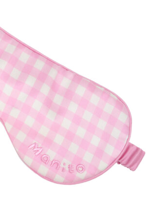 Close-up of the pink gingham silk sleep mask from the Blooming Gift Box with MANITO embroidery.