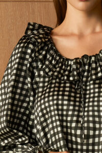 Close-up of black Blooming Women's Pajama Set neckline, highlighting soft ruffles and adjustable drawstring.