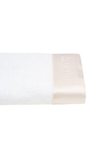 Close-up of silk-trimmed towel from Blush Bath Gift Set with MANITO logo.