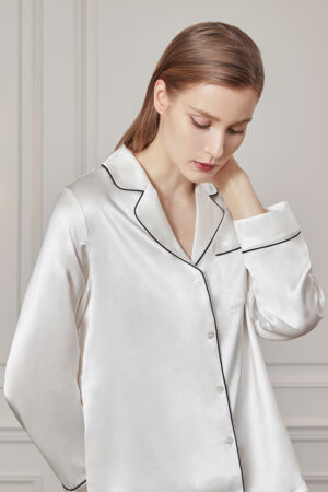Woman in contemplative pose wearing an Authentic Women's Silk Pajama Set in white.