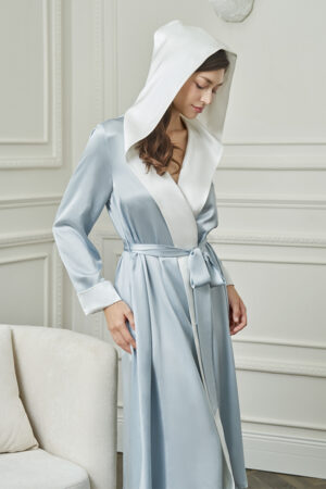 Woman in Calla Women's Hooded Bathrobe with hood draped, showcasing its smooth silk texture and relaxed silhouette.