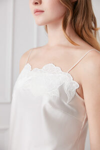 Close-up of floral embroidery on the neckline of the Camellia Women's Silk Camisole in blush pink.