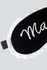 Front view of MANITO Charlotte Luxury Silk Eye Mask for Sleeping with white ruffle trim.