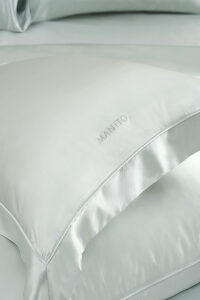 Detailed view of MANITO Classic Soft Light Bedding Set's fitted sheet in soft blue, showcasing the precise stitching.