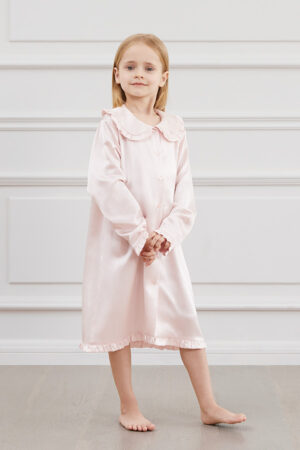 A girl wearing a pink Cloud Silk Nightgown with a classic collar and button details.