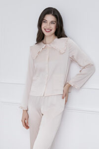 A woman wearing MANITO Cloud cute pink pajama set with a ruffled collar and stylish pockets.