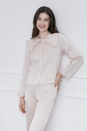 A woman wearing MANITO Cloud cute pink pajama set with a ruffled collar and stylish pockets.