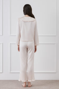 Back view of a woman in MANITO Cloud cute matching pajama set in pink, showcasing delicate ruffles on the collar and cuffs.