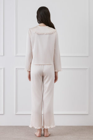 Back view of a woman in MANITO Cloud cute matching pajama set in pink, showcasing delicate ruffles on the collar and cuffs.