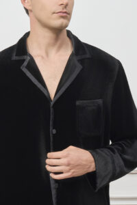 Close-up of man adjusting buttons on Combo Velvet Pajama Set top, highlighting satin piping and discreet logo chest pocket.