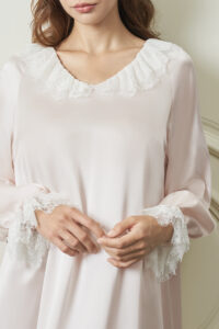 Close up of woman wearing Court Women's Nightdress, focusing on the lace V-neck and delicate lace cuffs with a silky touch.