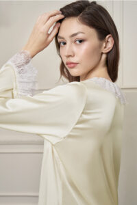 Side view of model in Court Women's Pajama Set, showcasing the flowing silk and delicate lace details.