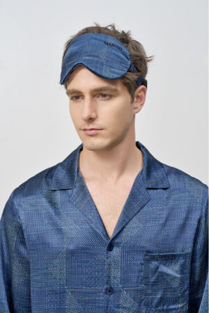 Model wears Cube Men's Eye Mask in navy geometric silk, showing ergonomic fit and soft comfort for restful sleep.