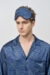 Model wears Cube Men's Eye Mask in navy geometric silk, showing ergonomic fit and soft comfort for restful sleep.