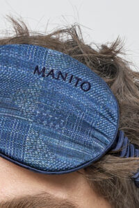 Close-up of Cube Men's Eye Mask with embroidered MANITO logo, showcasing refined craftsmanship and texture details.