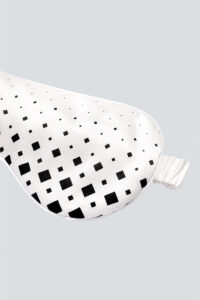 Detail shot of MNAITO Cubes Silk Eye Mask silk eye mask showcasing the intricate spiral diamond grid pattern.