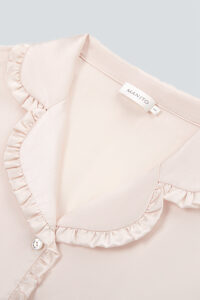 A close-up reveals the intricate ruffled collar of Daisy Women's Pink Pajama Set, adorned with the brand's label.