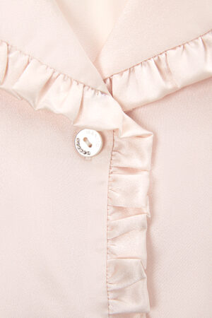 The front placket of Daisy Women's Pink Pajama Top is detailed with round, engraved buttons that bear the MANITO logo.