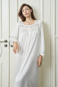 Woman wears Dream Women's Nightdress in white silk, with lace details and natural drape evoking calm morning elegance.