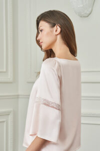 Side view of woman in MANITO Dream Women's Pajama Set, highlighting the soft sheen and delicate lace band on sleeves.