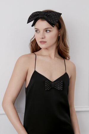 Model wearing Duchess Bow Silk Eye Mask, a cute sleep mask with a playful studded bow design, embellished with bows.