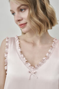 Close-up of MANITO Duchess Silk Ruffle Dress neckline in blush pink with small bow and ruffles.