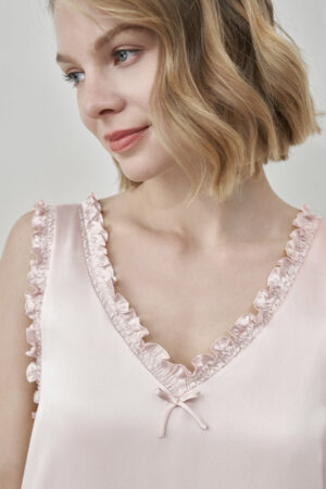 Close-up of MANITO Duchess Silk Ruffle Dress neckline in blush pink with small bow and ruffles.