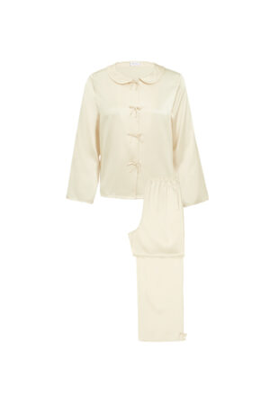 MANITO Duchess Women's Silk Pajama Set laid flat in cream, includes top and pants with bow accents.