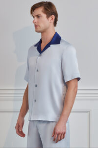 Side profile of model in silver gray MANITO Sketchy Silk Pajama Set with navy collar.