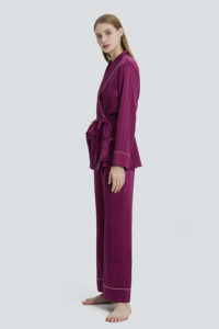 A woman wearing MANITO Embossed purple pajama set, standing barefoot.
