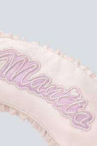 Detail view of Fairy Kid's Eye Mask embroidery with delicate pink MANITO lettering.