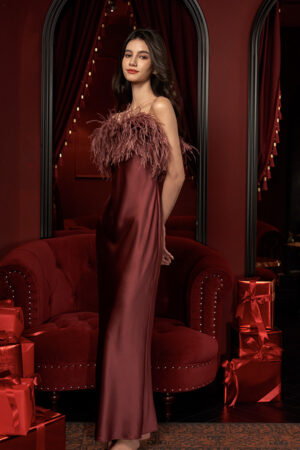 A model showcasing Fiesta red feather-bodice silk dress in a lavish setting.