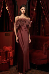 A model in Fiesta red feather-trimmed silk dress, captured from the front.