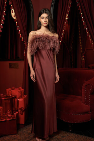 A model in Fiesta red feather-trimmed silk dress, captured from the front.