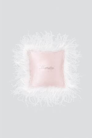 Pink holiday throw pillow with fluffy white feathers and a rhinestone logo, perfect for gifting.