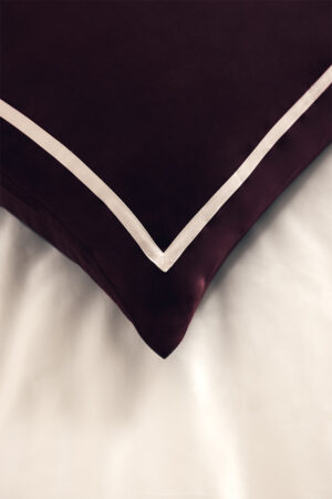 MANITO silk pillow with Bordeaux red fabric and white piping detail.