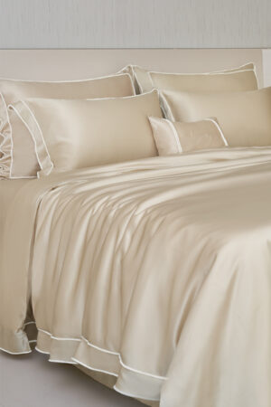 MANITO champagne Fringe Silk Duvet Cover on a bed with matching pillows, showcasing white fringe trims.