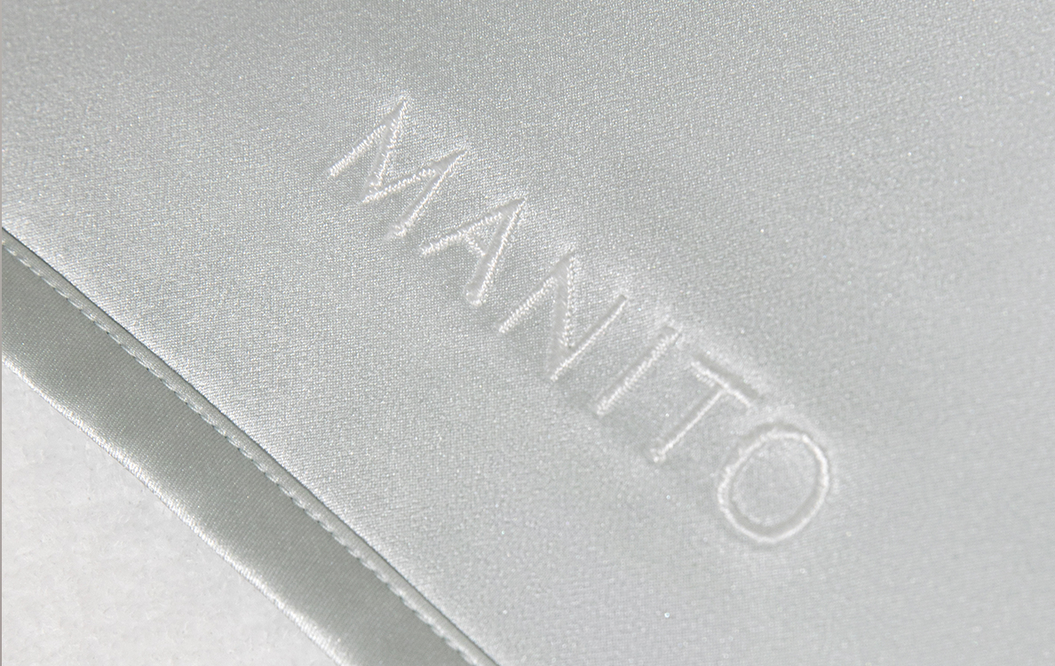 Premium mulberry silk pillowcase with embossed MANITO logo, showcasing understated luxury and superior comfort